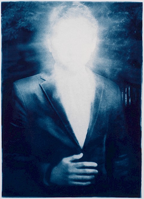 man in business suit with light emanating from his face suggesting enlightenment