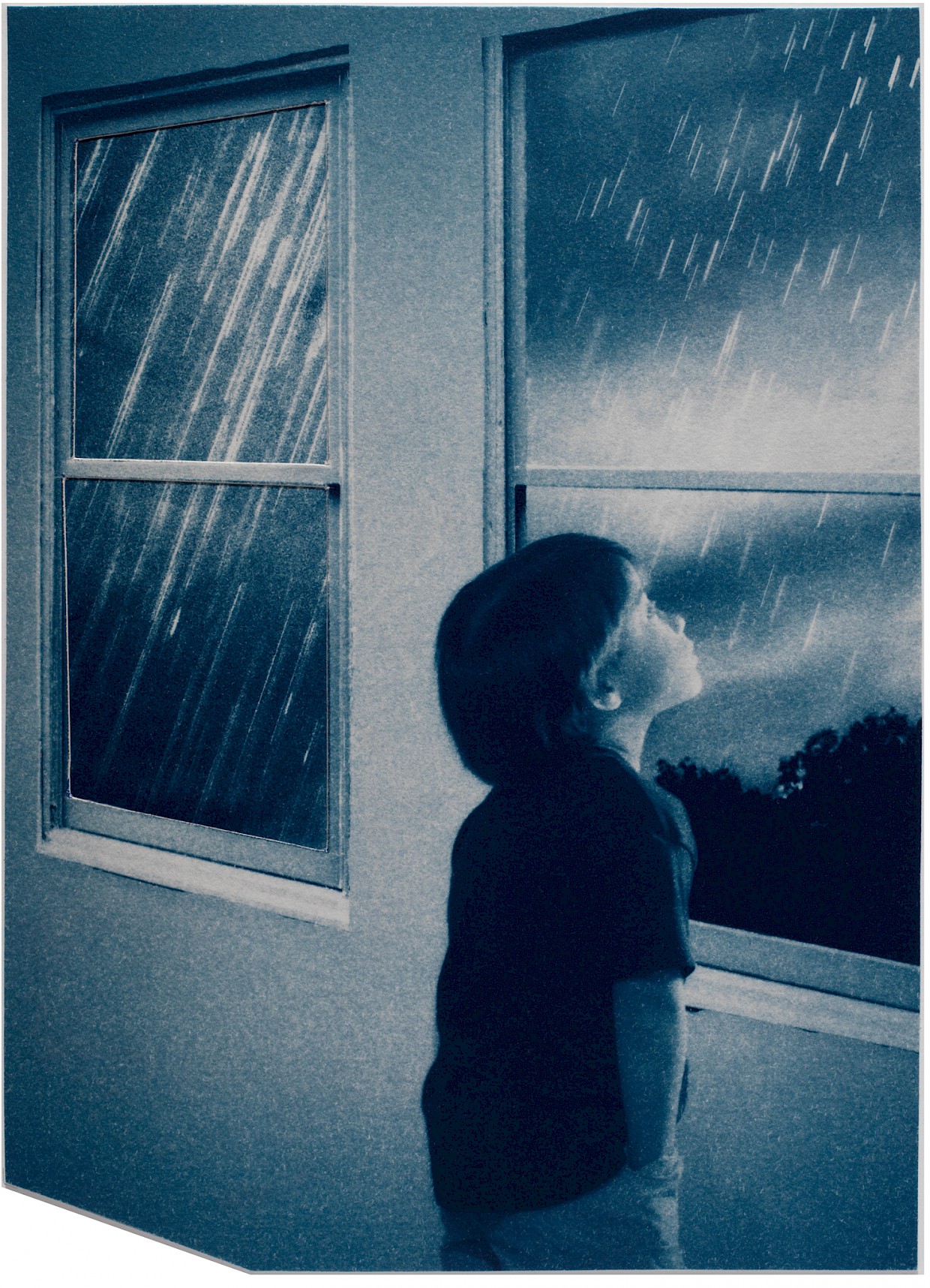 boy looking out window while it is raining
